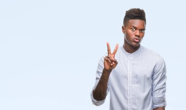 Gösterilen ve parmakları ile işaret izole arka plan üzerinde genç Afro-Amerikan adam ikincisi ise kendinden emin ve mutlu gülümseyerek.