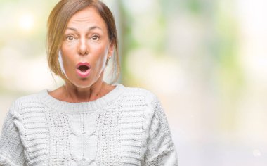 Orta yaş İspanyol kadın kıdemli giyen kış kazak korkuyor ve şok sürpriz ifade ile izole arka plan üzerinde korku ve yüz heyecanlı.