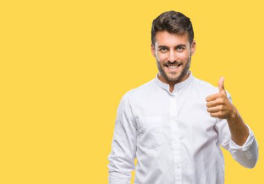 Yakışıklı delikanlı hareketi el ile mutlu yaşasın yapıyor izole arka plan üzerinde. Kameraya bakarak başarı gösteren ile ifade onaylama.