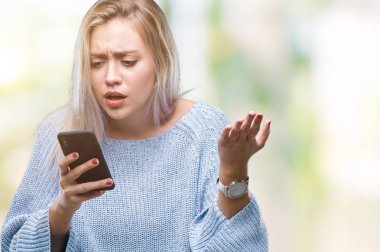 Sarışın genç kadın manifatura öfke, çılgın ve yükseltilmiş el, öfke kavramı ile diye bağıran ile smartphone üzerinde izole arka rahatsız ve sinirli bağırarak kullanarak ileti gönderme