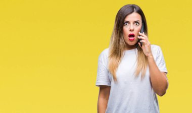 Arka plan bir sürpriz yüz, korkuyor ve heyecanlı korku ifadesi ile şok korkmuş üzerinden Smartphone kullanarak arama konuşan genç güzel kadın izole