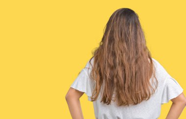 Genç güzel esmer iş kadını izole arka plan ayakta geriye doğru uzakta silah ile vücut üzerinde seyir üzerinde