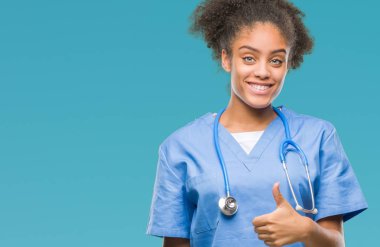 Genç afro Amerikalı doktor kadın hareketi el ile mutlu yaşasın yapıyor izole arka plan yüzünden. Kameraya bakarak başarı gösteren ile ifade onaylama.