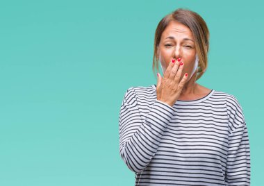 İspanyol kadın kıdemli orta yaş izole arka plan üzerinde el ile ağız kapsayan yorgun esneme sıkılmış. Restless ve uyku hali.