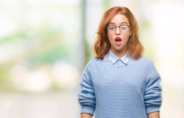 İzole arka plan kış kazak korkuyor ve şok sürpriz ifade, korku ve heyecan yüz ile giyen genç güzel kadın.