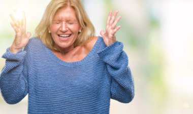 Arka plan deli kutluyor üzerinde kış kazak giyen orta yaş sarışın kadın izole ve crazy arms ile başarı için kaldırdı ve heyecanlı çığlık gözler kapalı. Kazanan kavramı