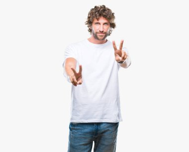 Zafer işareti yapıyor parmak gösterilen kamera seyir gülümseyen izole arka plan yakışıklı İspanyol modeli adam. İki numaralı.