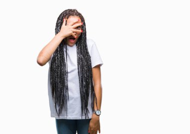 Genç saç Afro-Amerikan Kız yüz ve gözler el ile kapsayan şok bakmak izole arka plan üzerinde parmak utanç ifadesi ile bakarak örgülü.