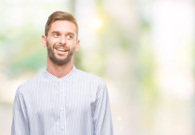 Yakışıklı delikanlı uzak tarafına yüzünde, doğal ifade gülümseme ile seyir izole arka plan üzerinde. Kendine güvenen gülüyor.