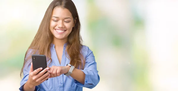 年轻美丽的黑发女商人使用智能手机在孤立的背景与幸福的脸站在和一个自信的微笑显示牙齿 — 图库照片