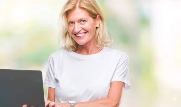 中年金发碧眼的女人使用电脑笔记本电脑在孤立的背景与幸福的脸站着 面带微笑 自信的微笑显示牙齿 — 图库照片