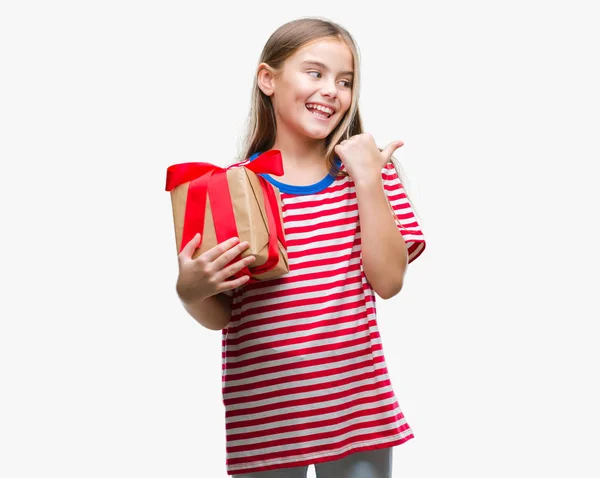 年轻美丽的女孩给圣诞节或情人节礼物在孤立的背景指向和显示与拇指面带笑脸微笑 — 图库照片