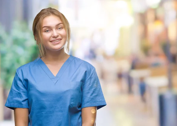 年轻的高加索护士妇女穿着外科医生制服在孤立的背景与一个快乐和冷静的笑容在脸上 幸运的人 — 图库照片