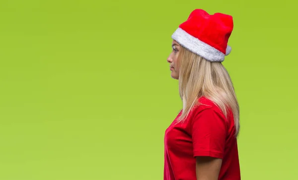年轻的白种人妇女戴着圣诞节帽子在孤立的背景寻找一边 放松的轮廓姿势与自然脸与自信的微笑 — 图库照片
