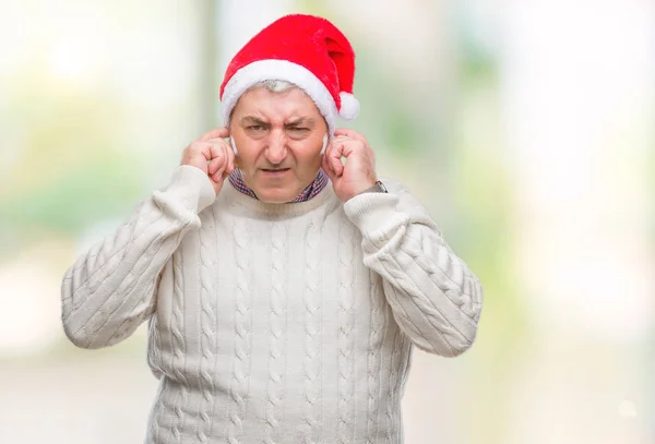 ハンサムな年配の男性は 大声で音楽の音の腹が立つ式の指を使って耳をカバー分離の背景にクリスマス帽子をかぶっています 聴覚障害者の概念 — ストック写真