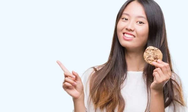 Joven Asiático Mujer Comer Chocolate Chip Cookie Sobre Aislado Fondo —  Fotos de Stock