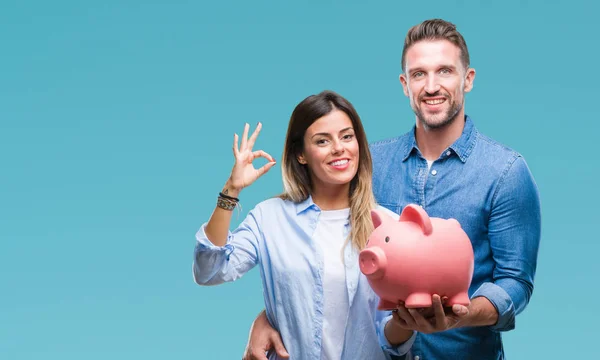 Young Couple Love Holding Piggy Bank Isolated Background Doing Sign — Stock Photo, Image