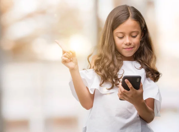 Menina Hispânica Morena Usando Smartphone Muito Feliz Apontando Com Mão — Fotografia de Stock