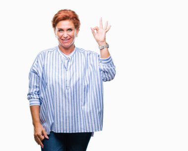 Atrractive üst düzey beyaz Kızıl saçlı kadın izole arka plan el ve parmaklar ok işaretiyle yapıyor olumlu gülümseyen üzerinde. Başarılı ifade.