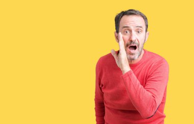 Yakışıklı orta yaş ağarmış komuta sizde giyen kış kazak izole arka plan üzerinde el gizli söylenti, kötü niyetli konuşma konuşma fısıldayarak söylemek dudaklarından