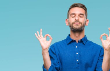 Yakışıklı delikanlı izole arka plan üzerinde dinlenmek ve gülümseyen gözlerle parmak ile meditasyon jest yapıyor kapalı. Yoga kavramı.