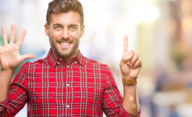 Yakışıklı delikanlı gösterilen ve parmakları ile işaret izole arka plan üzerinde kendinden emin ve mutlu gülümseyerek süre 6 numara.