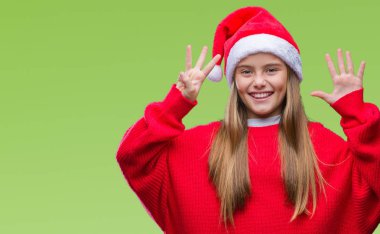 Genç güzel kız giyen Noel şapka gösterilen ve parmakları ile işaret izole arka plan üzerinde kendinden emin ve mutlu gülümseyerek süre sekiz numara.