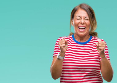 İspanyol kadın kıdemli orta yaş izole arka kolları olan başarı için heyecan üzerinde zafer kutluyor gülümseyen kaldırdı. Kazanan kavramı.