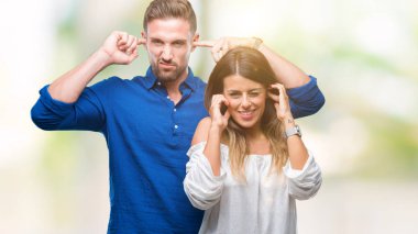 Yüksek sesle müzik gürültü rahatsız ifade parmaklarıyla kulaklarıyla kapsayan izole arka plan üzerinde aşık genç bir çift. Sağır kavramı.