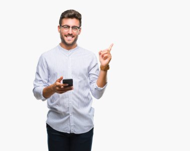 Genç yakışıklı adam akıllı telefon kullanan izole arka tarafına el ve parmak ile işaret çok mutlu üzerinden manifatura