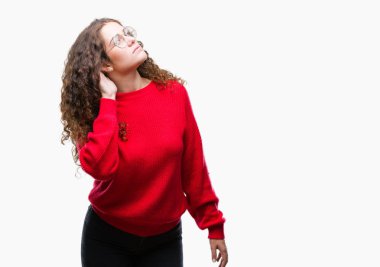 Güzel esmer kıvırcık saçlı Genç kız bir işitme söylenti ya da dedikodu için dinleme kulak üzerinde el ile gülümseyen izole arka plan üzerinde gözlük ve kış kazak giyiyor. Sağırlık kavramı.