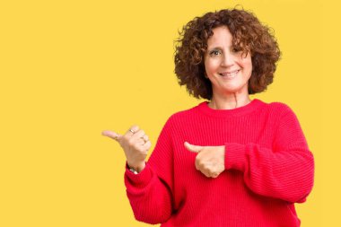 Güzel orta ager üst düzey kadın kırmızı kış kazak izole arka plan üzerinde emin gülümseyen arkasından el ve kadar başparmak ile işaret