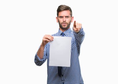 Yakışıklı delikanlı holding boş kağıt izole arka kamera ve size parmak ile işaret üzerine, el işareti, pozitif ve kendinden emin bir jest ön