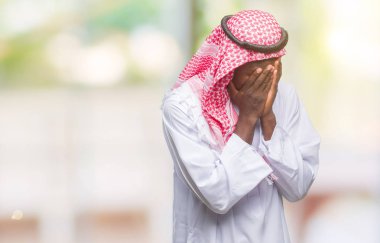 Yüzünü elleriyle ağlayarak süre kapsayan üzgün ifade ile izole arka plan üzerinde geleneksel keffiyeh giyen genç Arapça Afrika adam. Depresyon kavramı.