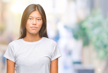 Genç Asyalı kadın yüzünde ciddi bir ifade ile izole arka plan üzerinde. Basit ve doğal kameraya bakıyor.