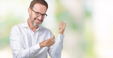 Üzerinde gözlük takan yakışıklı orta yaş zarif üst düzey iş adamı izole arka plan emin gülümseyen arkasından el ve kadar başparmak ile işaret