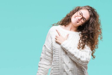 İzole arka neşeli bir gülümseme ile el ve parmak kadar kameraya bakarak yüzündeki mutlu ve doğal ifade ile yan ile işaret yüz üzerinden kış kazak giyen güzel esmer kıvırcık saçlı Genç kız.