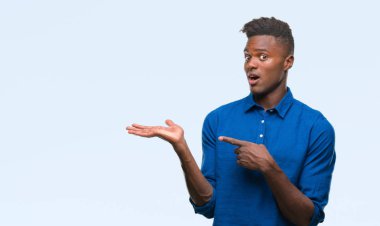 Genç Afro-Amerikan adam üzerinden hayran ve el ile sunulması ve parmak ile işaret ederken kameraya gülümseyen izole arka plan.