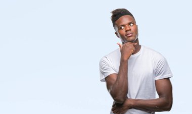 Afrikalı-Amerikalı genç çene düşünme hakkında soru, dalgın ifade üzerine el ile izole arka plan üzerinde. Düşünceli yüzüyle gülümsüyor. Şüphe kavramı.