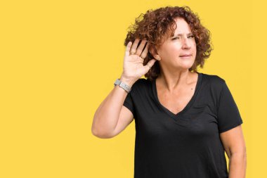 Güzel orta ager üst düzey kadın bir işitme söylenti ya da dedikodu için dinleme kulak üzerinde el ile gülümseyen izole arka plan yüzünden. Sağırlık kavramı.