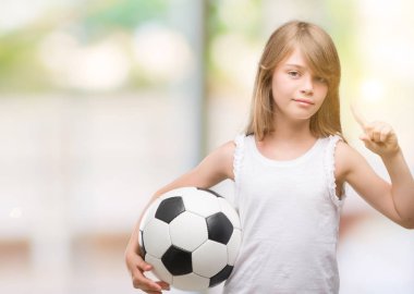 Genç Sarışın yürümeye başlayan çocuk futbol topu sürpriz bir fikir ya da soru işaret parmağı gülen yüz, bir numara ile tutarak