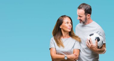 Orta yaş İspanyol çift acımak yüz ciddi düşünüyorum üstünde kendine güvenen bir ifade ile izole arka plan üzerinde futbol futbol topu tutan