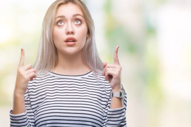 Sarışın genç kadın izole arka plan üzerinden hayran ve yukarıya bakıp parmakları ile işaret şaşırttı ve silah kaldırdı.