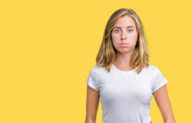 Komik surat ile yanakları şişirme izole arka plan üzerinde rahat beyaz t-shirt giyen güzel ve genç birbayan. Ağız ile hava, deli ifade şişirilmiş.