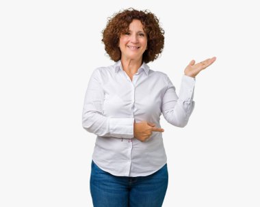 Neşeli sunulması ve kameraya bakarak avucunun ile işaret gülümseyen izole arka plan güzel orta ager üst düzey businees kadın.