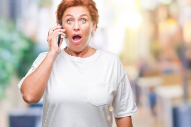 Atrractive üst düzey beyaz Kızıl saçlı kadın Smartphone'da izole arka plan üzerinde bir sürpriz yüz, korkuyor ve heyecanlı korku ifadesi ile şok korkmuş söz