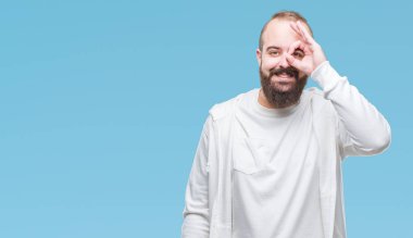 Genç beyaz hipster adam gülümsüyor, parmakları ile mutlu yüz üzerinden seyir göz el ile ok jest yapıyor izole arka plan üzerinde spor giyim eşyası.