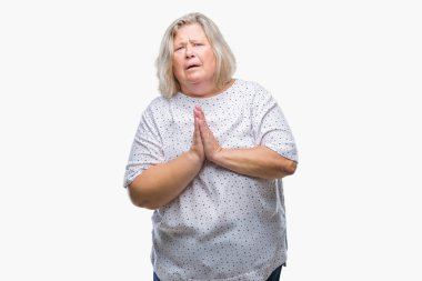 Kıdemli artı boyutu ile birlikte eller yalvarıyor ve dua ile izole arka plan üzerinde beyaz kadın yüzüne çok duygusal ve endişeli ifade umuyoruz. Bağışlanmak. Din kavramı.