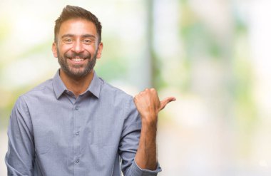 Seyir ve başparmak yanında yukarıyı mutlu yüz ile gülümseyen izole arka plan yetişkin İspanyol adam.