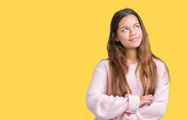 Görünümlü yan ve dik dik bakma uzağa düşünce gülümseyen izole arka plan üzerinde pembe kış kazak giyen genç güzel esmer kadın.